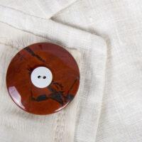 Jasper Trauerknopf mit einem Knopf eines geliebten Menschen als Brosche an einer Sommerjacke.